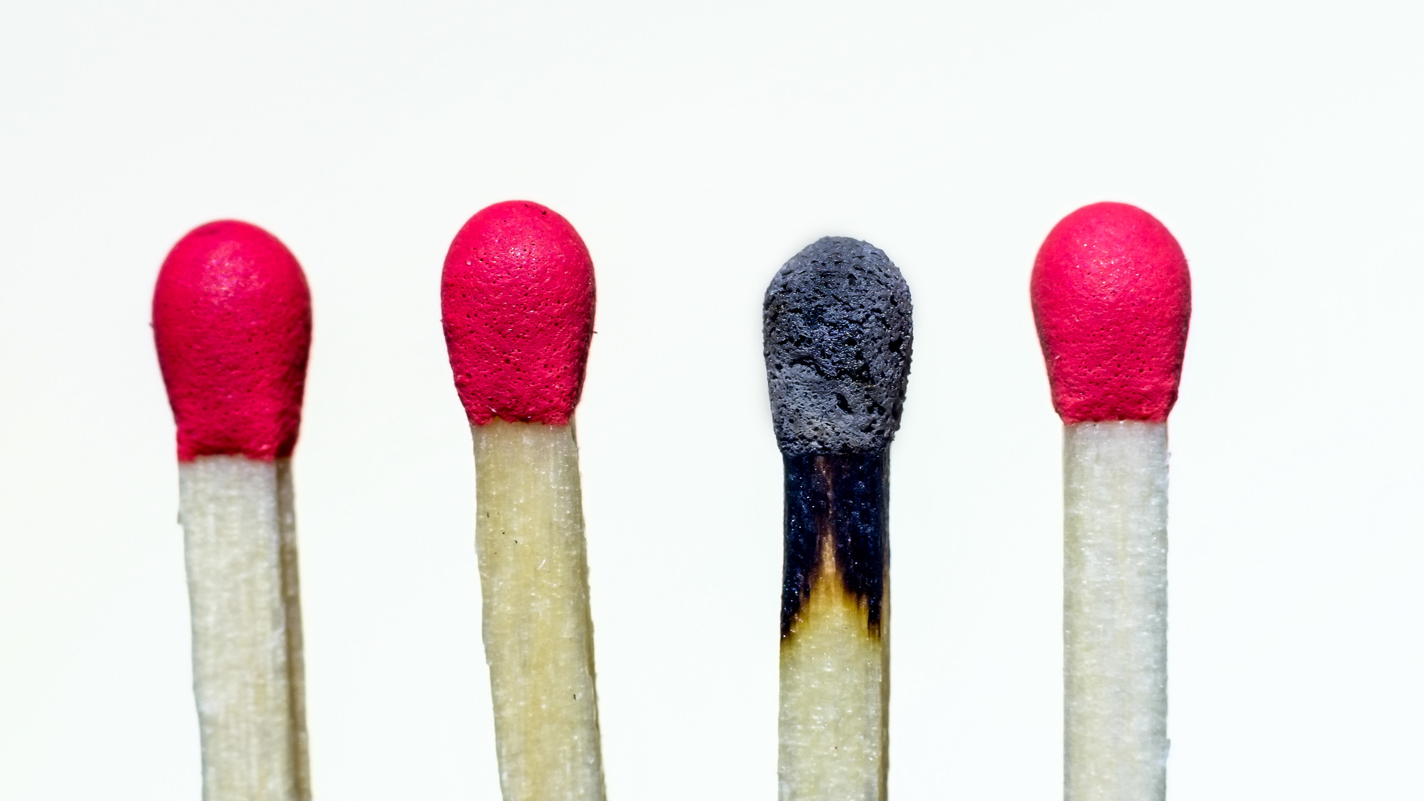 Image of 4 matches against a white background. One of the matches is already burnt.